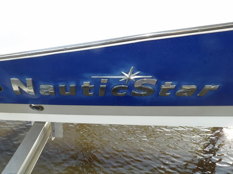 Slide: The Image of 2018 NauticStar 203DC Sport Deck boat logo on blue hull. - 4