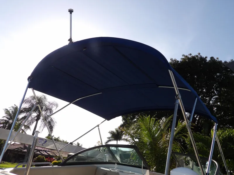 Slide: The Image of 2018 NauticStar 203DC Sport Deck with blue bimini top. - 9