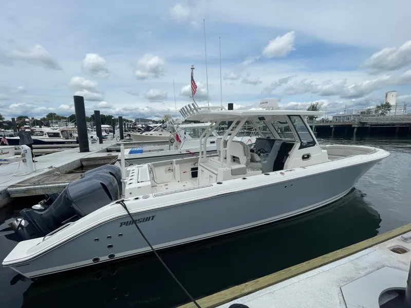 Slide: The Image of 2022 Pursuit S 328 Sport boat docked at a marina. - 13
