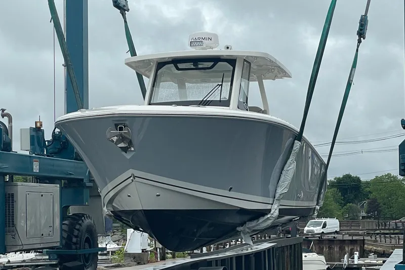 Slide: The Image of 2022 Pursuit S 328 Sport boat being lifted at a marina. - 14
