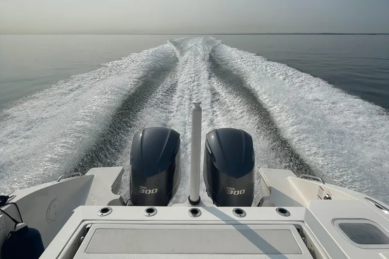 Slide: The Image of 2022 Pursuit S 328 Sport boat with twin Yamaha 300 engines on calm water. - 20