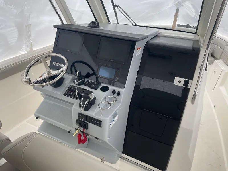 Slide: The Image of 2022 Pursuit S 328 Sport boat helm with dual screens and modern controls. - 29