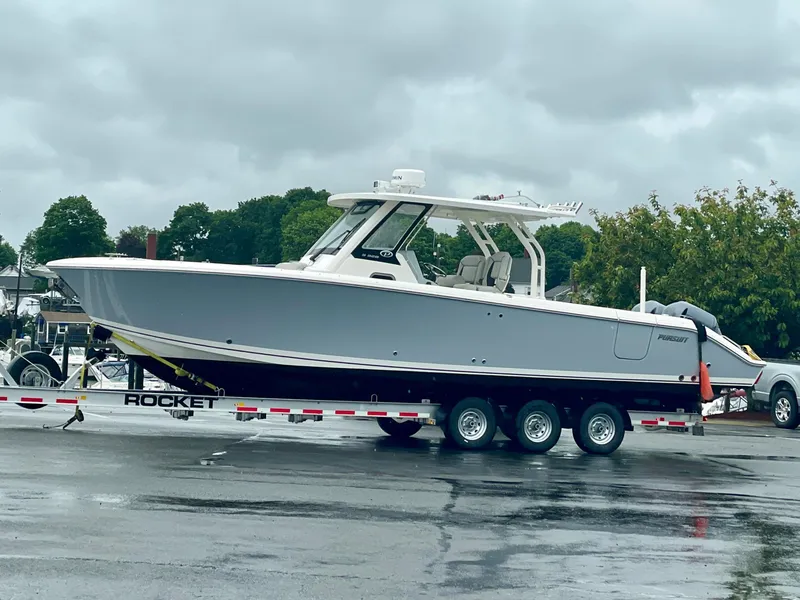 Slide: The Image of 2022 Pursuit S 328 Sport boat on a trailer in a parking lot. - 4