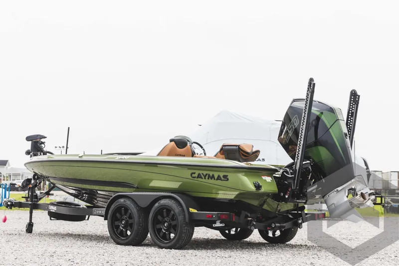 Slide: The Image of 2024 Caymas XS 20 Pro boat in green, parked on a gravel lot. - 7