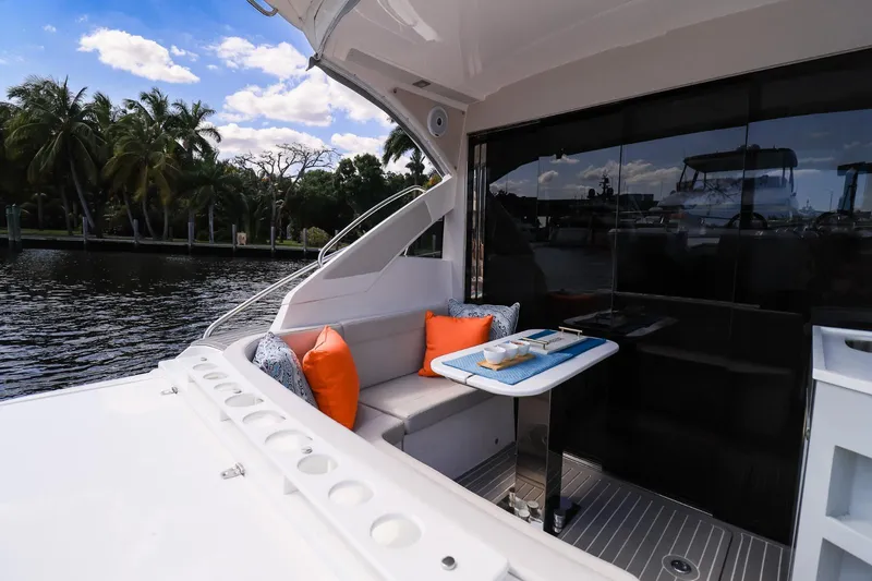 Slide: The Image of Luxury Evolve 400HT yacht interior with seating, table, and waterfront view, 2021 model. - 14