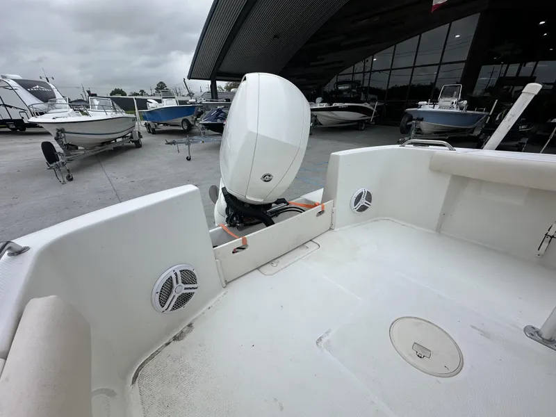 Slide: The Image of 2014 Mako 204 CC boat with outboard motor, docked at a marina with other boats. - 5