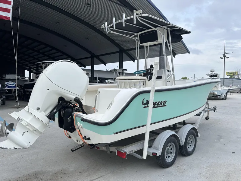 Slide: The Image of 2014 Mako 204 CC boat on trailer with outboard motor in marina. - 7