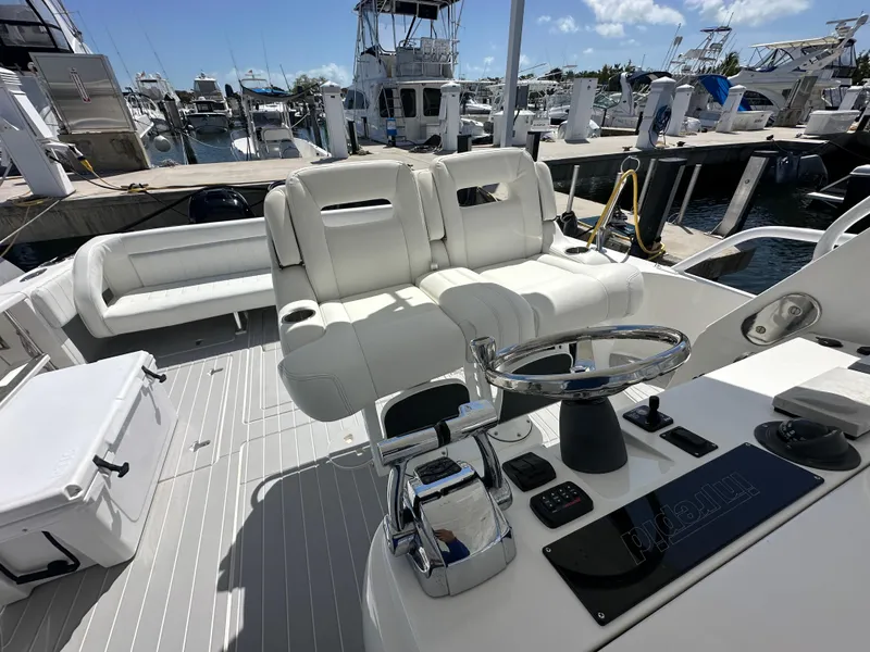 Slide: The Image of 2008 Intrepid 390 Sport Yacht at marina, featuring helm and seating area. - 10