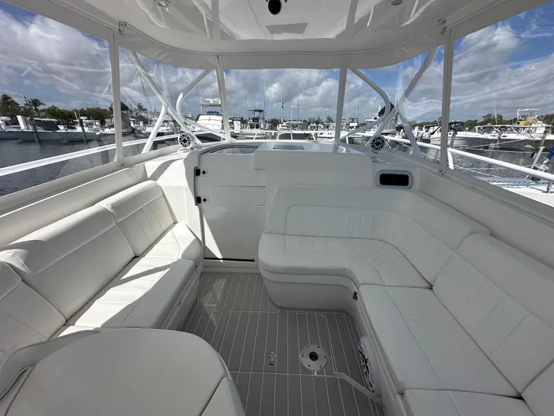 Slide: The Image of 2008 Intrepid 390 Sport Yacht interior with white seating, docked at marina. - 13
