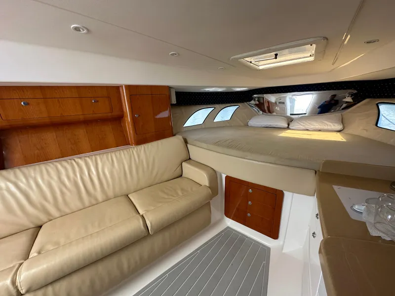 Slide: The Image of Interior of 2008 Intrepid 390 Sport Yacht with beige leather sofa and cozy sleeping area. - 21