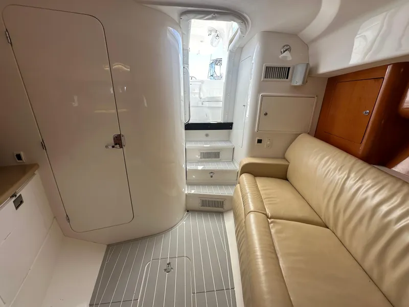 Slide: The Image of Interior of 2008 Intrepid 390 Sport Yacht with beige leather seating and white cabinetry. - 22