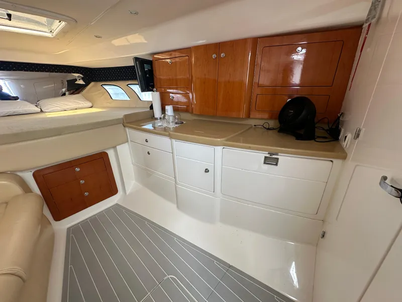 Slide: The Image of Interior of a 2008 Intrepid 390 Sport Yacht with wooden cabinets and a cozy sleeping area. - 23