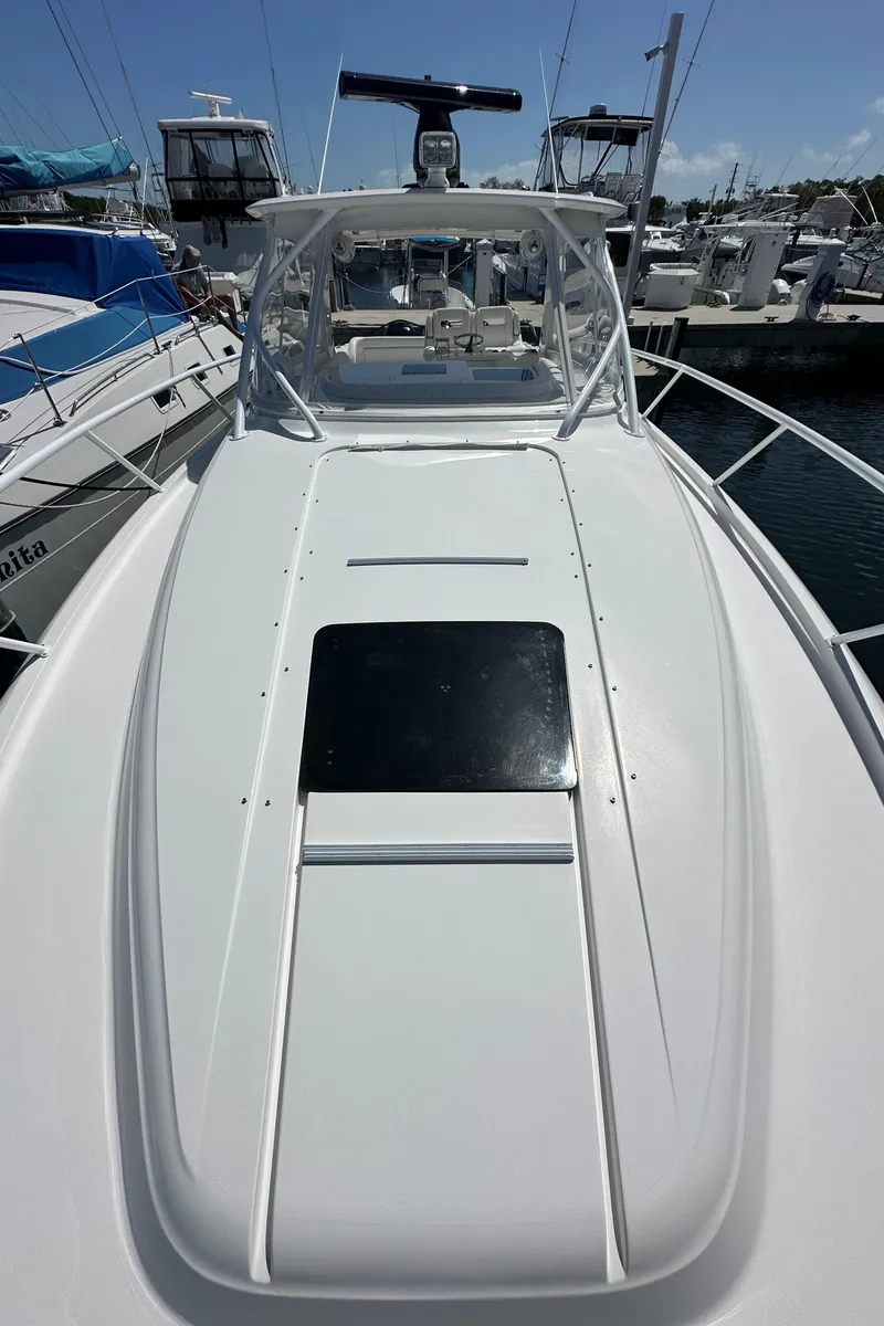 Slide: The Image of 2008 Intrepid 390 Sport Yacht docked, showcasing sleek design and spacious deck. - 5