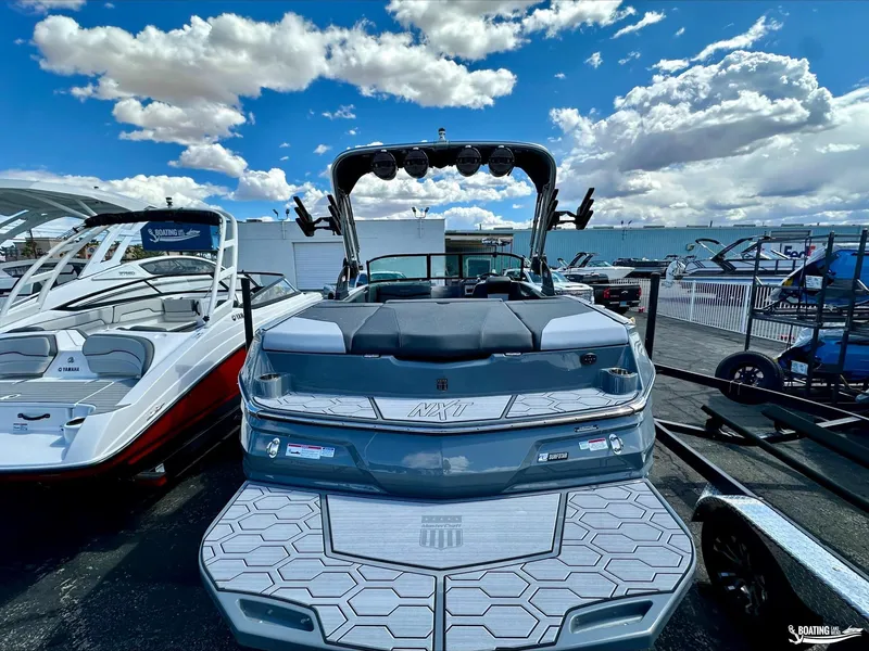 Slide: The Image of 2024 MasterCraft NXT21 boat displayed outdoors under a blue sky with clouds. - 3