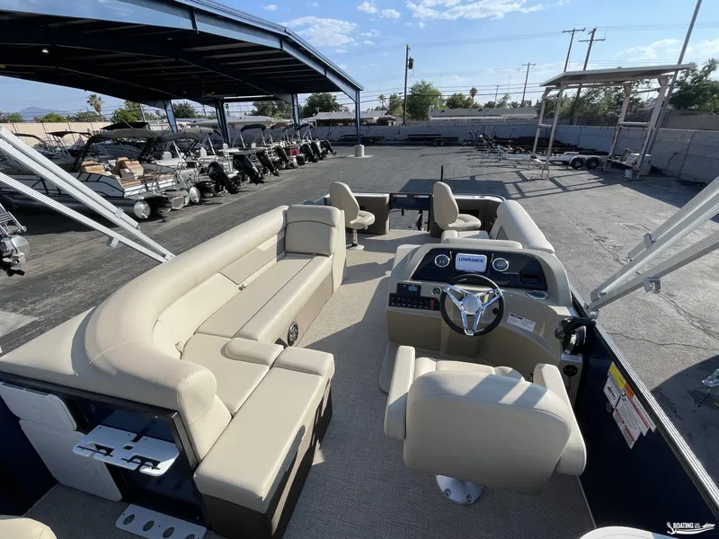 Slide: The Image of 2023 Crest 200 Classic Fish pontoon boat interior with beige seating and steering console. - 6