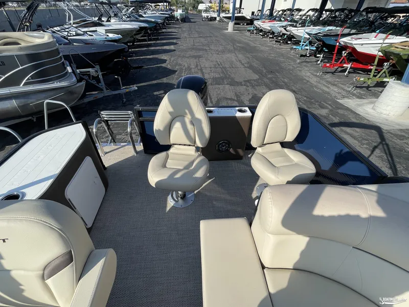 Slide: The Image of 2023 Crest 200 Classic Fish pontoon boat interior with beige seating and fishing setup. - 7