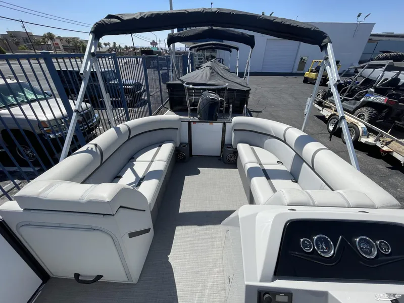 Slide: The Image of 2023 Crest 220 LX Classic SLS pontoon boat with spacious seating and modern dashboard. - 2