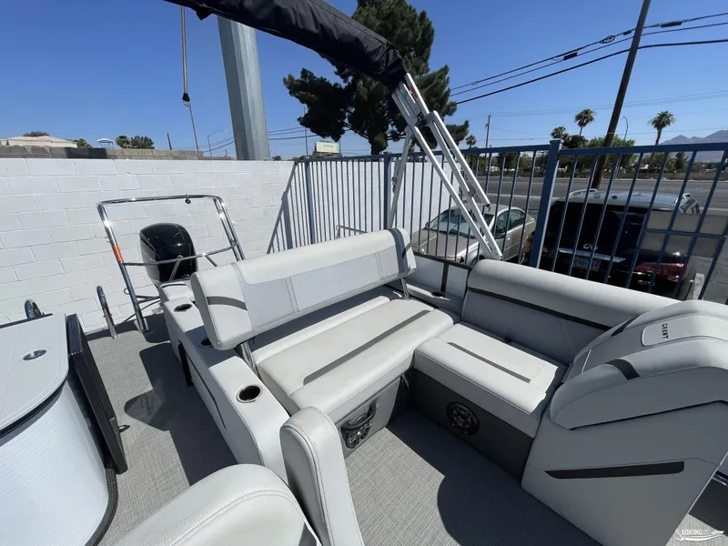 Slide: The Image of 2023 Crest 220 LX Classic SLS pontoon boat interior with seating and motor. - 6