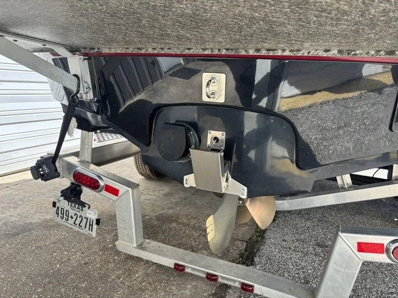 Slide: The Image of 2010 Nautique Super Air Nautique 226 boat on trailer, rear view showing propeller and license plate. - 2