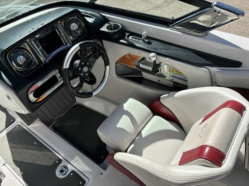 Slide: The Image of 2010 Nautique Super Air Nautique 226 boat cockpit with steering wheel and dashboard. - 4