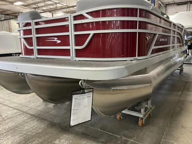 Slide: The Image of 2024 Bennington 22 SVSR-SPS pontoon boat with red cover in a warehouse. - 2