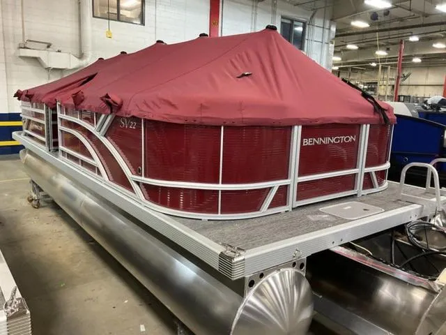 Slide: The Image of 2024 Bennington 22 SVSR-SPS pontoon boat with red canopy in a warehouse. - 5