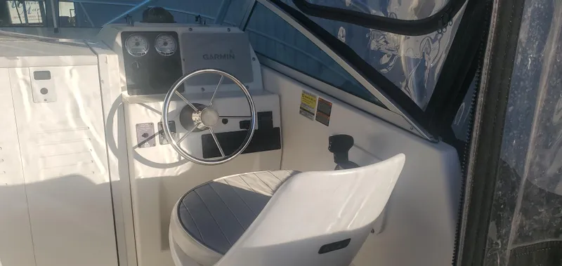Slide: The Image of 2000 Robalo 2240 Walkaround boat cockpit with steering wheel and gauges. - 11