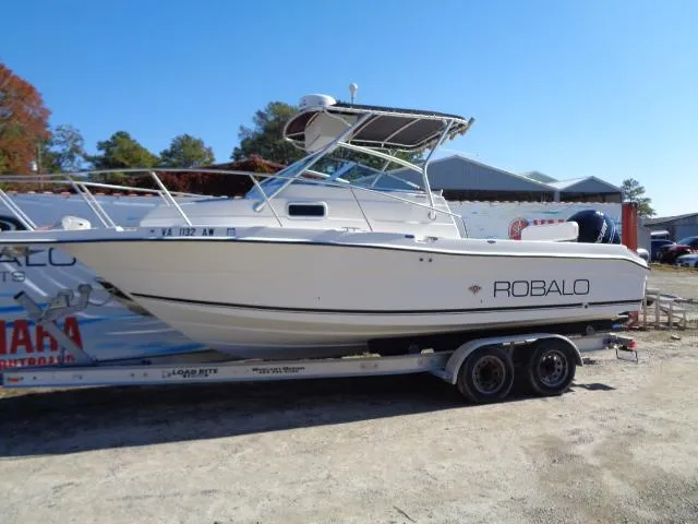Slide: The Image of 2000 Robalo 2240 Walkaround boat on a trailer in a yard. - 15
