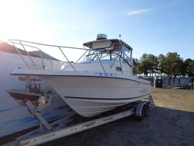 Slide: The Image of 2000 Robalo 2240 Walkaround boat on a trailer in a parking lot. - 2
