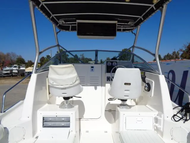 Slide: The Image of 2000 Robalo 2240 Walkaround boat cockpit with dual white captain chairs. - 20