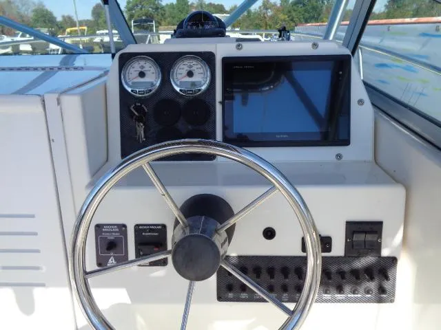 Slide: The Image of 2000 Robalo 2240 Walkaround boat dashboard with steering wheel and gauges. - 22