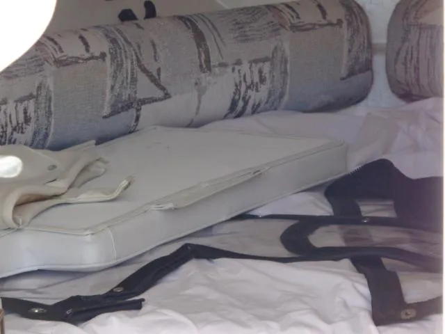 Slide: The Image of Interior cabin of a 2000 Robalo 2240 Walkaround boat with cushions and storage. - 28