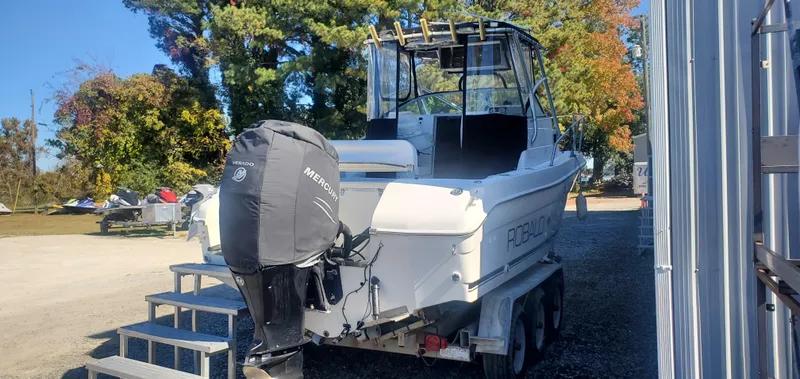 Slide: The Image of 2000 Robalo 2240 Walkaround boat on trailer, parked outdoors. - 3