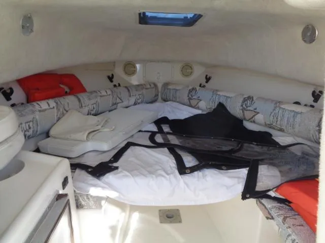 Slide: The Image of Interior cabin of a 2000 Robalo 2240 Walkaround boat with cushions and storage. - 30