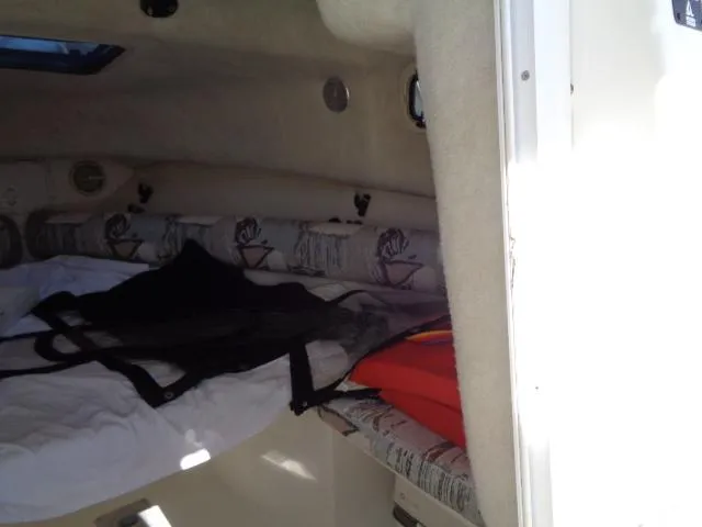 Slide: The Image of Interior cabin of a 2000 Robalo 2240 Walkaround boat with bedding and life jackets. - 31
