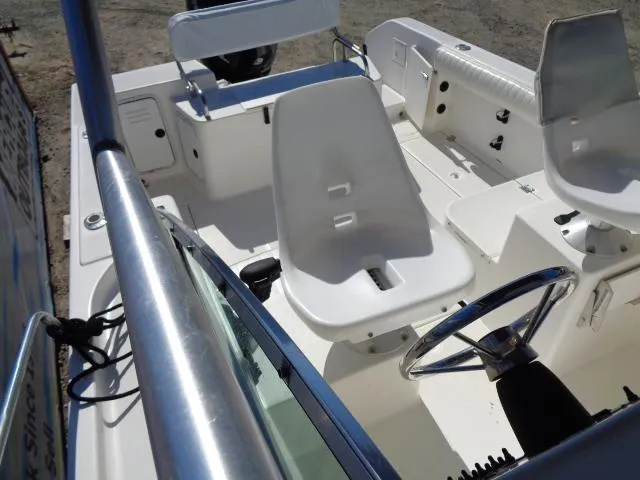 Slide: The Image of 2000 Robalo 2240 Walkaround boat interior with white seating and steering wheel. - 34