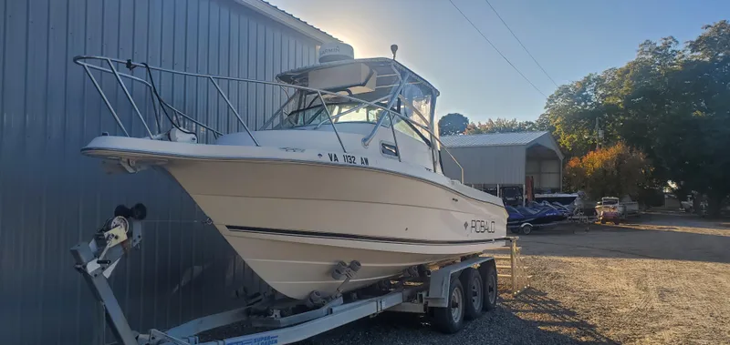 Slide: The Image of 2000 Robalo 2240 Walkaround boat on trailer near metal building. - 4