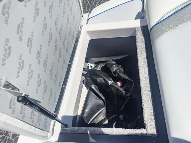 Slide: The Image of Open storage compartment in 2013 Supra SA 350 boat with black bag inside. - 16