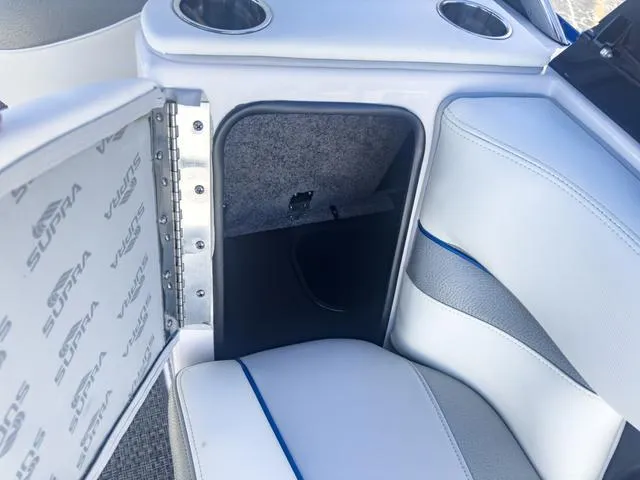 Slide: The Image of Open storage compartment in a 2013 Supra SA 350 boat with white and blue interior. - 20