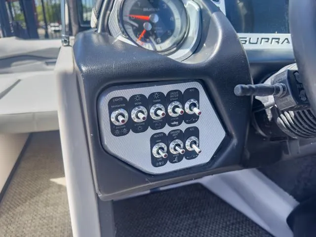Slide: The Image of Control panel of a 2013 Supra SA 350 boat with various switches and gauges. - 29
