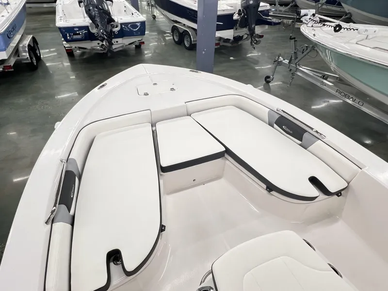 Slide: The Image of 2024 Robalo ROBALO 206 boat interior with white cushioned seating in showroom. - 6