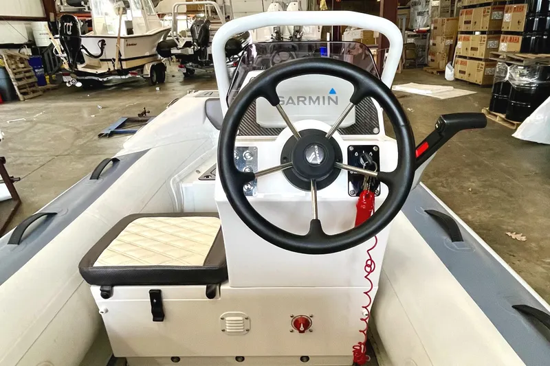 Slide: The Image of 2022 Highfield SP300 boat console with Garmin steering wheel in a warehouse setting. - 5