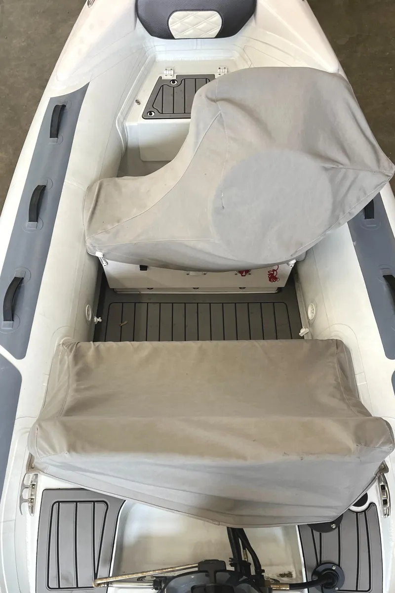 Slide: The Image of 2022 Highfield SP300 boat interior with covered seats and gray flooring. - 6