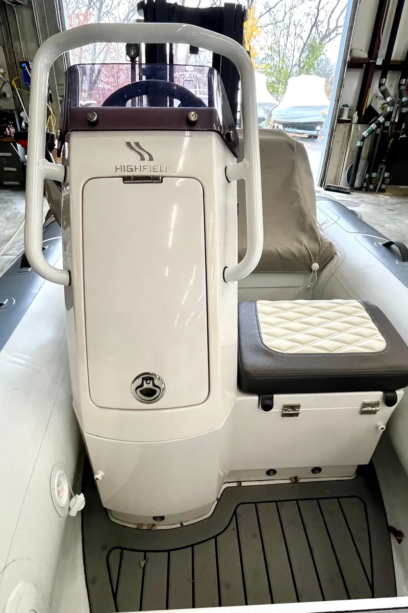 Slide: The Image of 2022 Highfield SP300 boat interior with cushioned seating and steering console. - 8