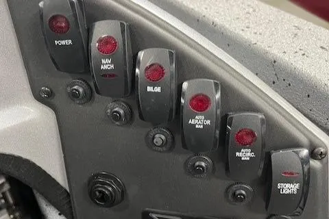 Slide: The Image of Control panel of a 2022 Express XPRESS X19PRO boat with various switches. - 14