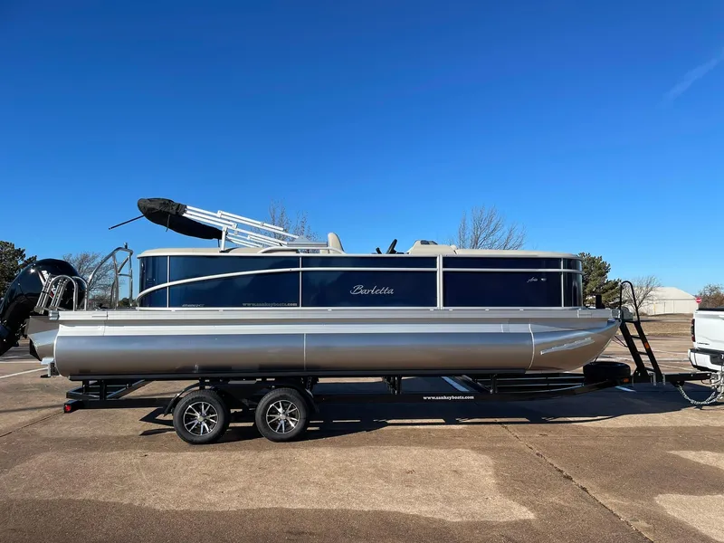 Slide: The Image of 2024 Barletta ARIA 22QC pontoon boat on a trailer under a clear blue sky. - 14