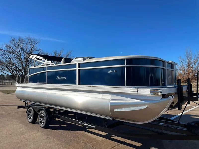 Slide: The Image of 2024 Barletta ARIA 22QC pontoon boat on a trailer under a clear blue sky. - 16