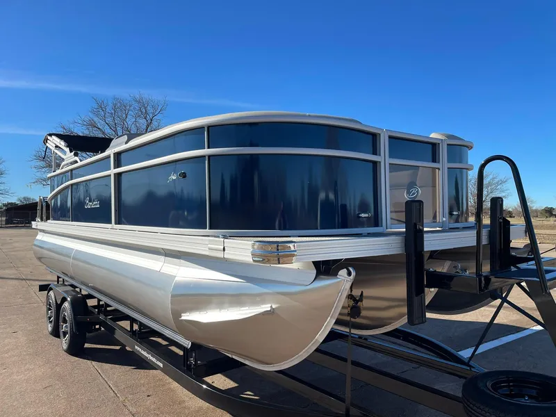 Slide: The Image of 2024 Barletta ARIA 22QC pontoon boat on a trailer under a clear blue sky. - 17