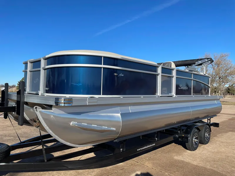Slide: The Image of 2024 Barletta ARIA 22QC pontoon boat on trailer, blue and silver exterior. - 4