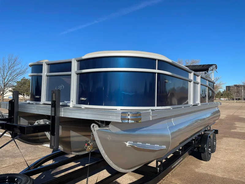 Slide: The Image of 2024 Barletta ARIA 22QC pontoon boat on a trailer under a clear blue sky. - 5